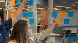 在健康创新和创业练习中，学生们把便利贴贴在墙上