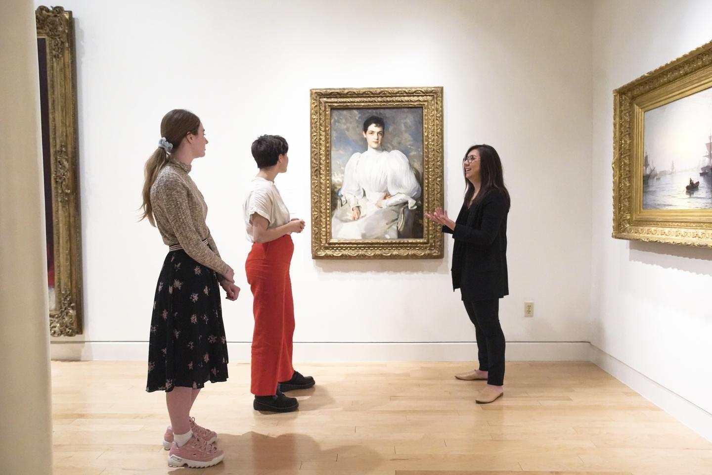 2 People standing in front of a portrait with a docent